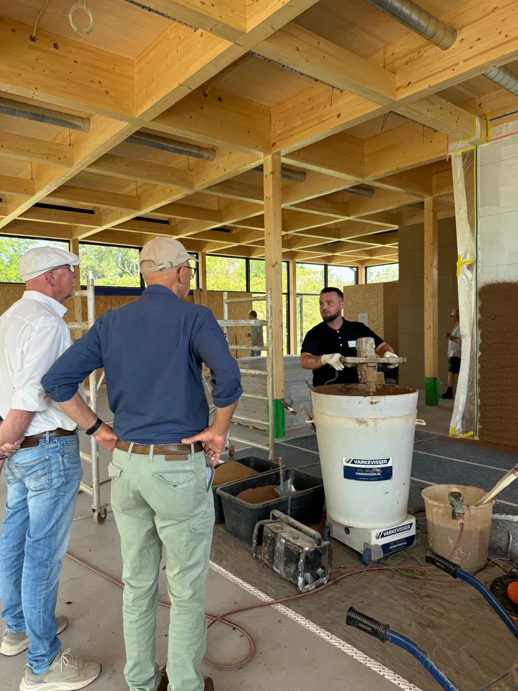 Tim legt op de bouw uit hoe de leem in een menger wordt aangemaakt